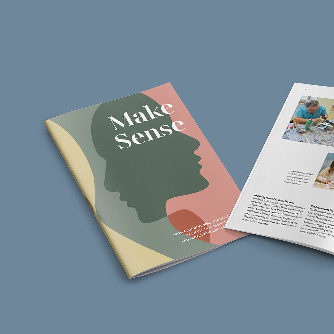 Magazine titled 'Make Sense' with a green silhouette on a pink cover, open to pages showing people working on crafts and a garden with buildings.