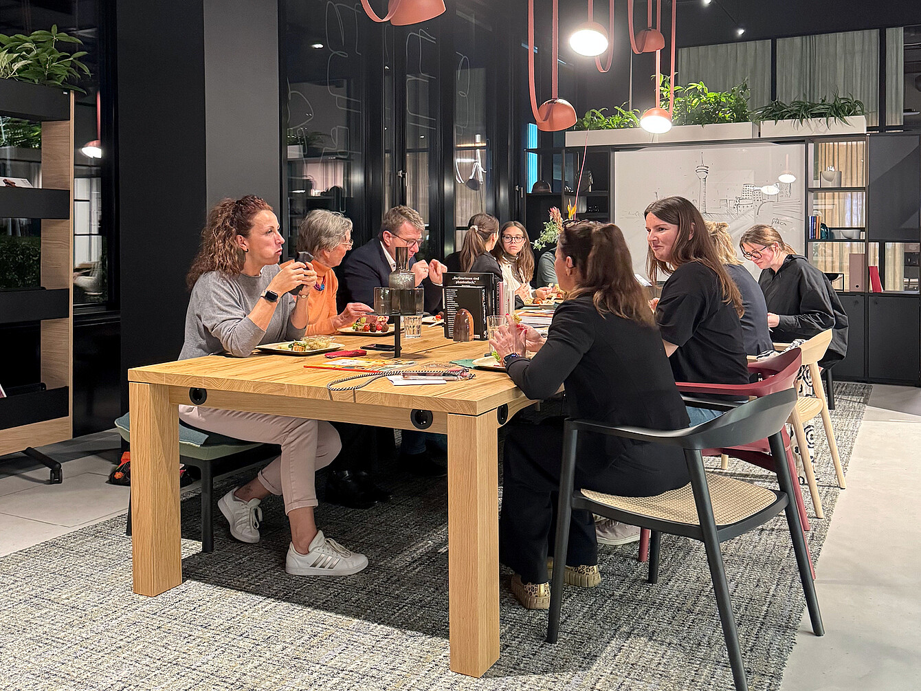 Visitors to HUB West eat together at the team table