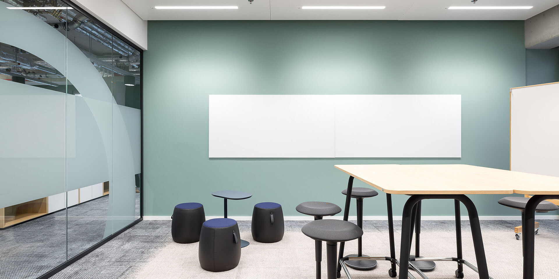 Moderner Besprechungsraum mit se:lab high desk Workshop-Tisch, se:fit Stehsitzen und universellen se:dot Hockern für agiles Arbeiten und Zusammenarbeit. 