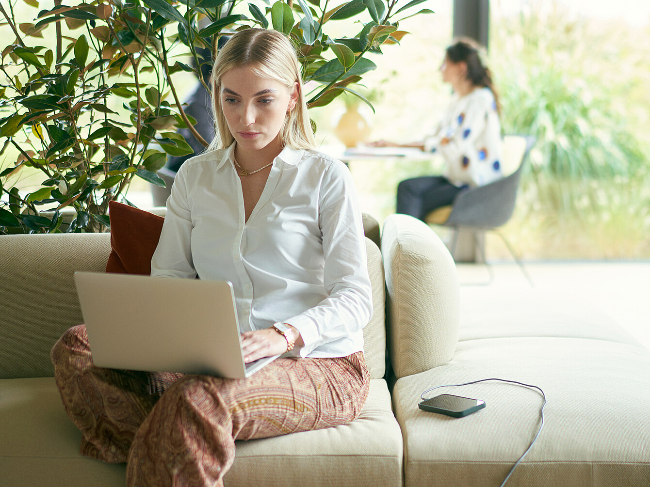 Frau sitzt auf dem se:living sofa und arbeitet