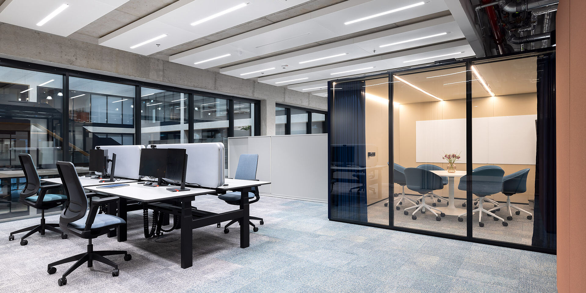 Moderne Teamarbeitsplätze bei Veolia mit höhenverstellbaren Doppel-Arbeitsplätzen 'temptation smart twin' und ergonomischen se:flex Drehstühlen in hellem, offenem Büro. 