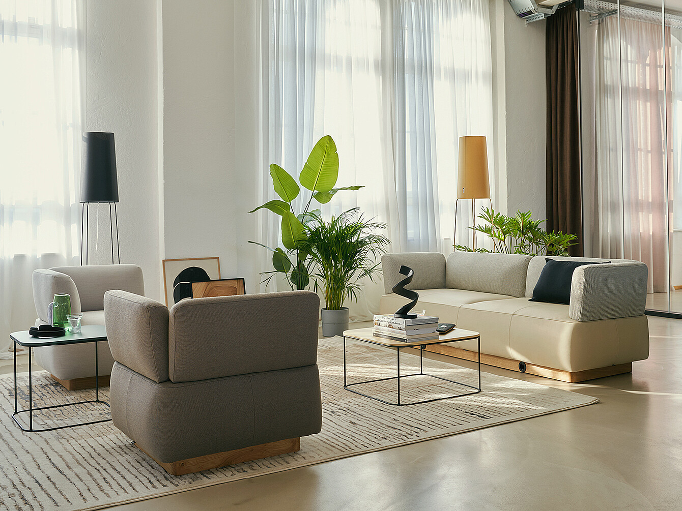 Entspannter, stilvoller Work Café Club mit bequemen Sofas, Pflanzen und minimalistischen Tischen in heller Business Lounge