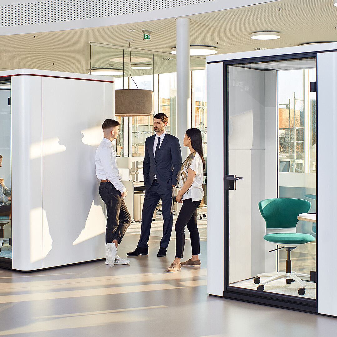Modern office with se:cube and se:cube max room-in-room solutions featuring new touch displays for intuitive lighting and ventilation control, with people interacting nearby
