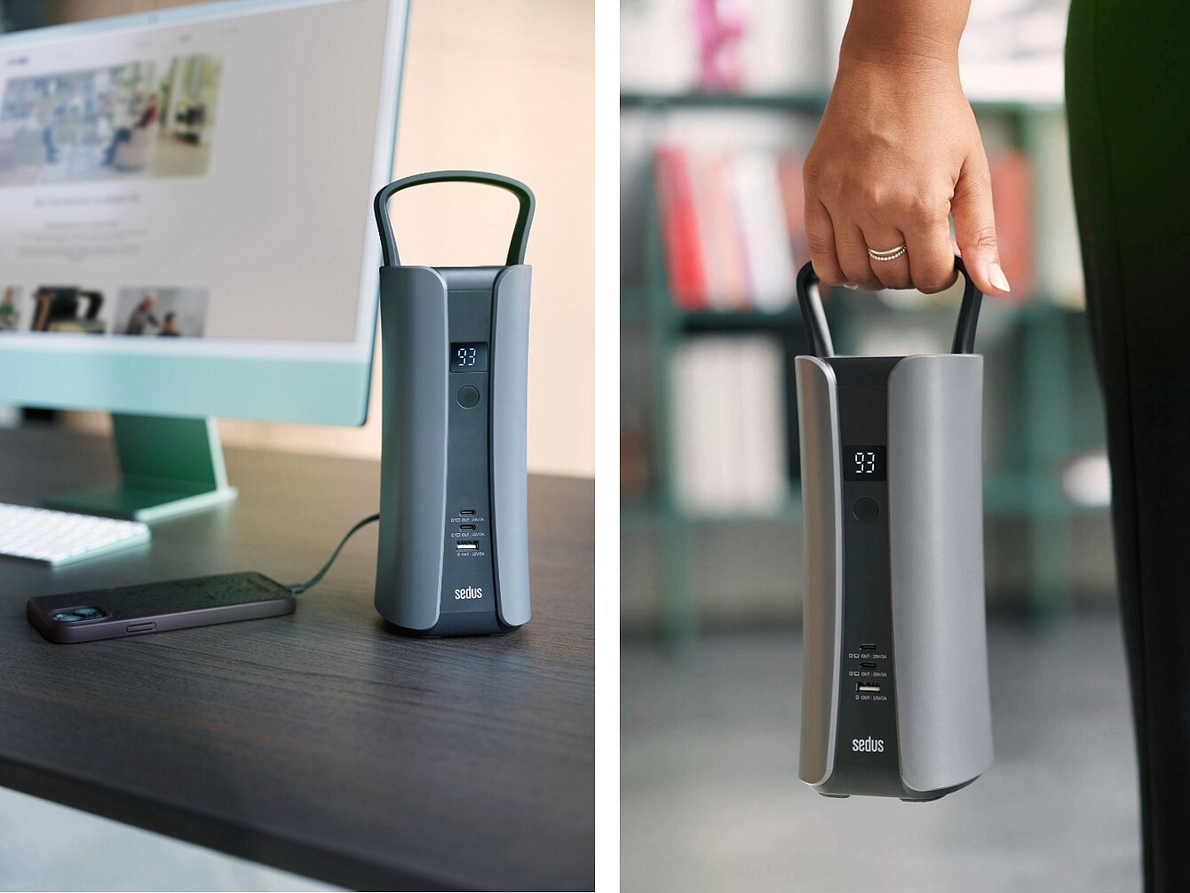 Portable battery with a handle and digital display showing '93' on a desk next to a computer and a hand holding the battery by its handle