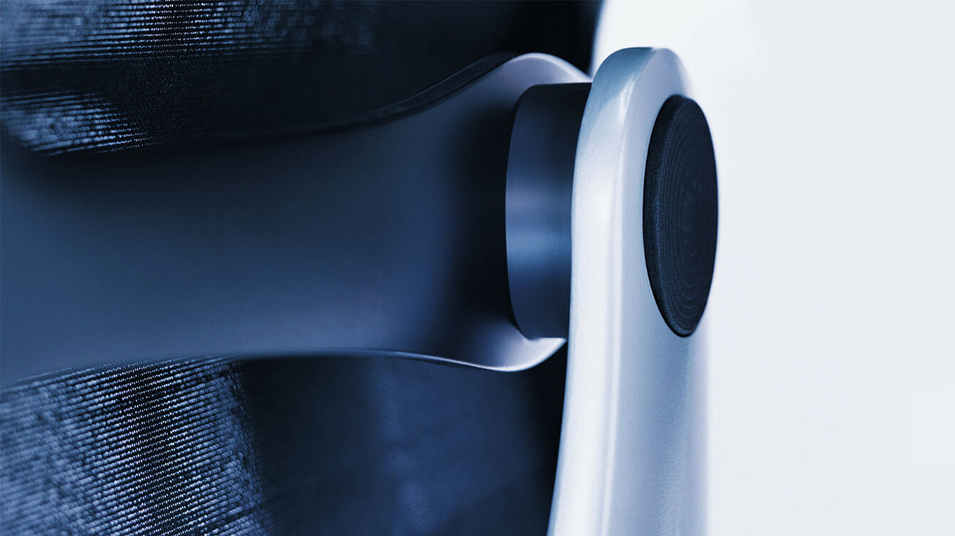 Close-up of the dorsokinetic mechanism in the backrest of a Sedus black dot office chair, showing the black circular joint connecting the backrest to the frame